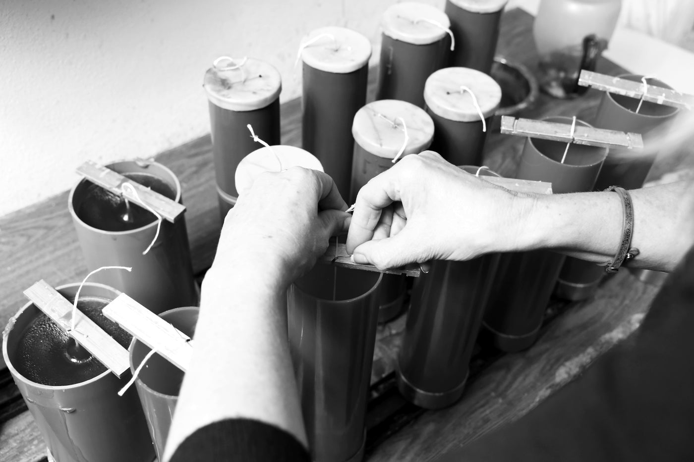Handarbeit in der Kerzenmanufaktur – Docht wird in gegossene Kerzen eingesetzt