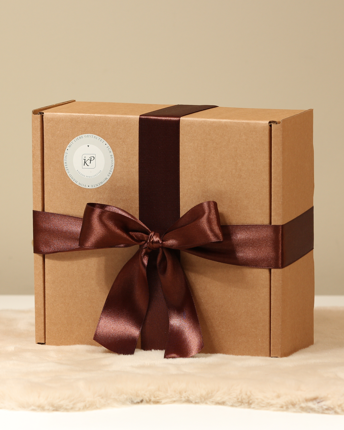 Nachhaltig verpackte Geschenkbox mit braunem Satinband – Kerzen Pfeilstetter