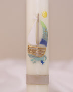 Nahaufnahme des maritimen Motivs mit Segelschiff und goldener Sonne – handverziert auf Kommunionskerze von Wiedemann.