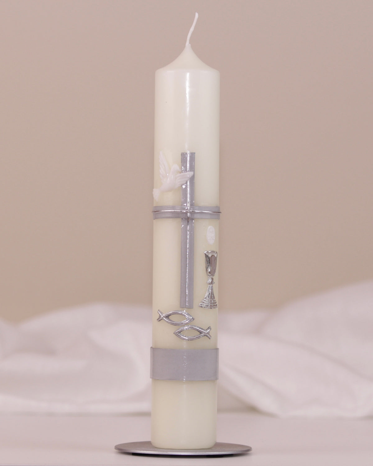Kommunionskerze mit silbernem Kreuz, Taube, Kelch und Fischsymbol auf weißem Hintergrund – traditionell verziert von Wiedemann.