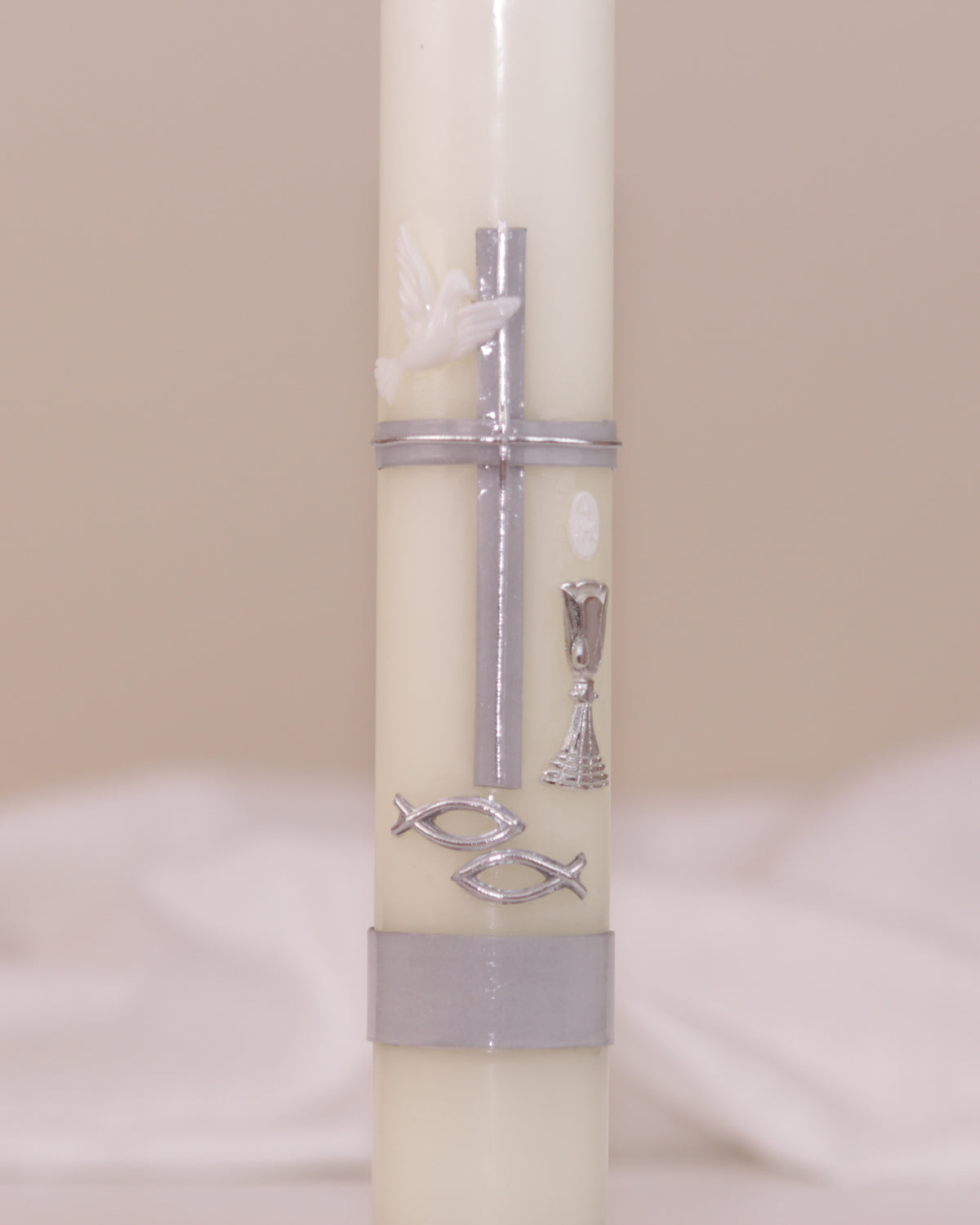 Detailansicht der silbernen Verzierung mit Kreuz, Taube, Kelch und Fischsymbol – handverziert auf Kommunionskerze von Wiedemann.