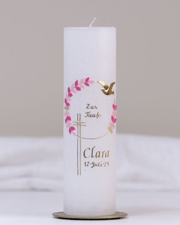 Weiße Taufkerze mit gold-pinker Verzierung aus Kreuz, Blumenranke, Taube und „Zur Taufe“-Schriftzug.