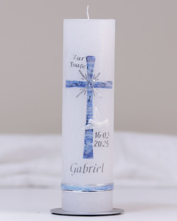 Weiße Taufkerze mit silber-blauer Verzierung aus Kreuz, Taube und „Zur Taufe“-Schriftzug.
