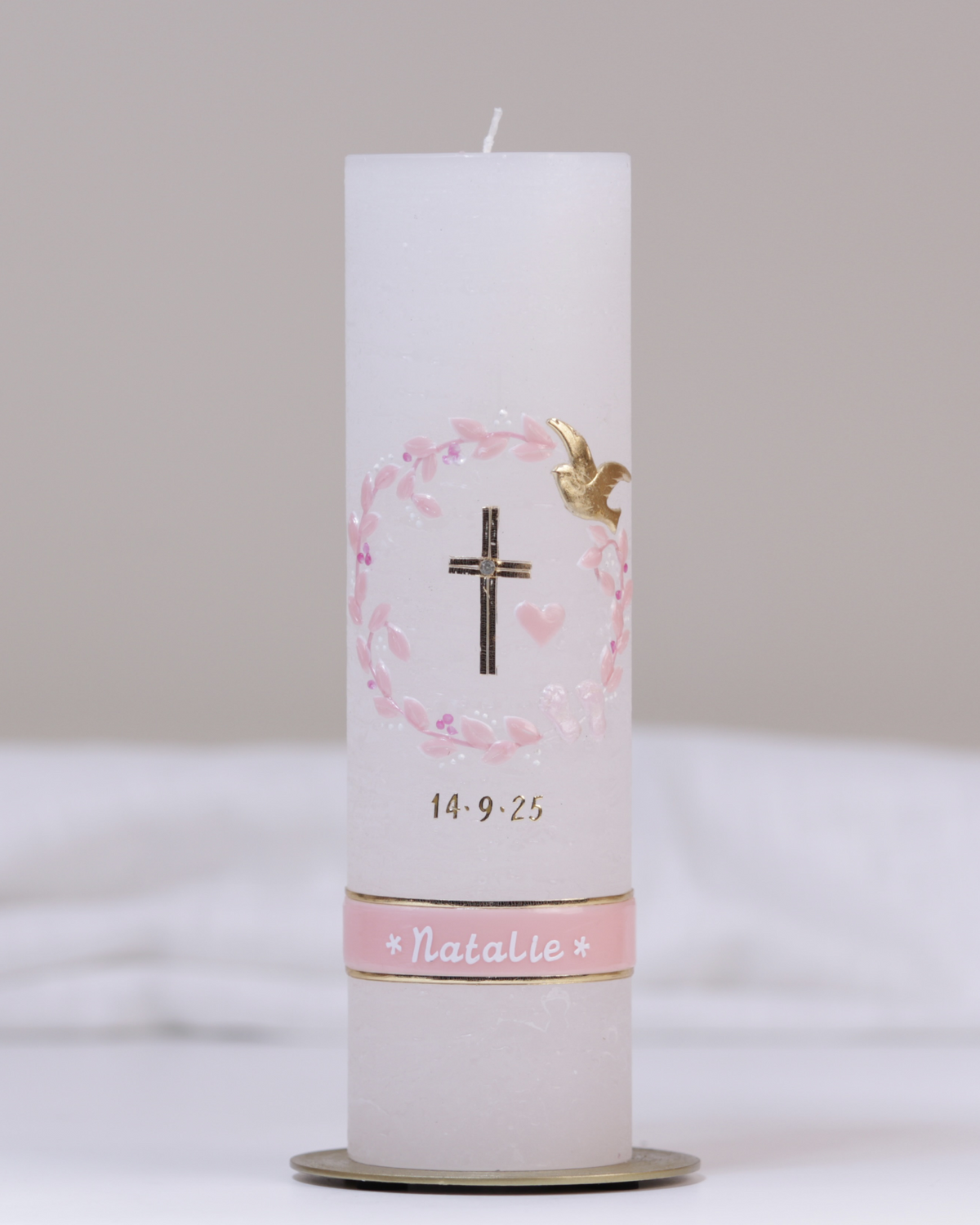 Weiße Taufkerze mit gold-rosa Verzierung aus Kreuz, Herz, Blumenranke und Schmetterlingen.