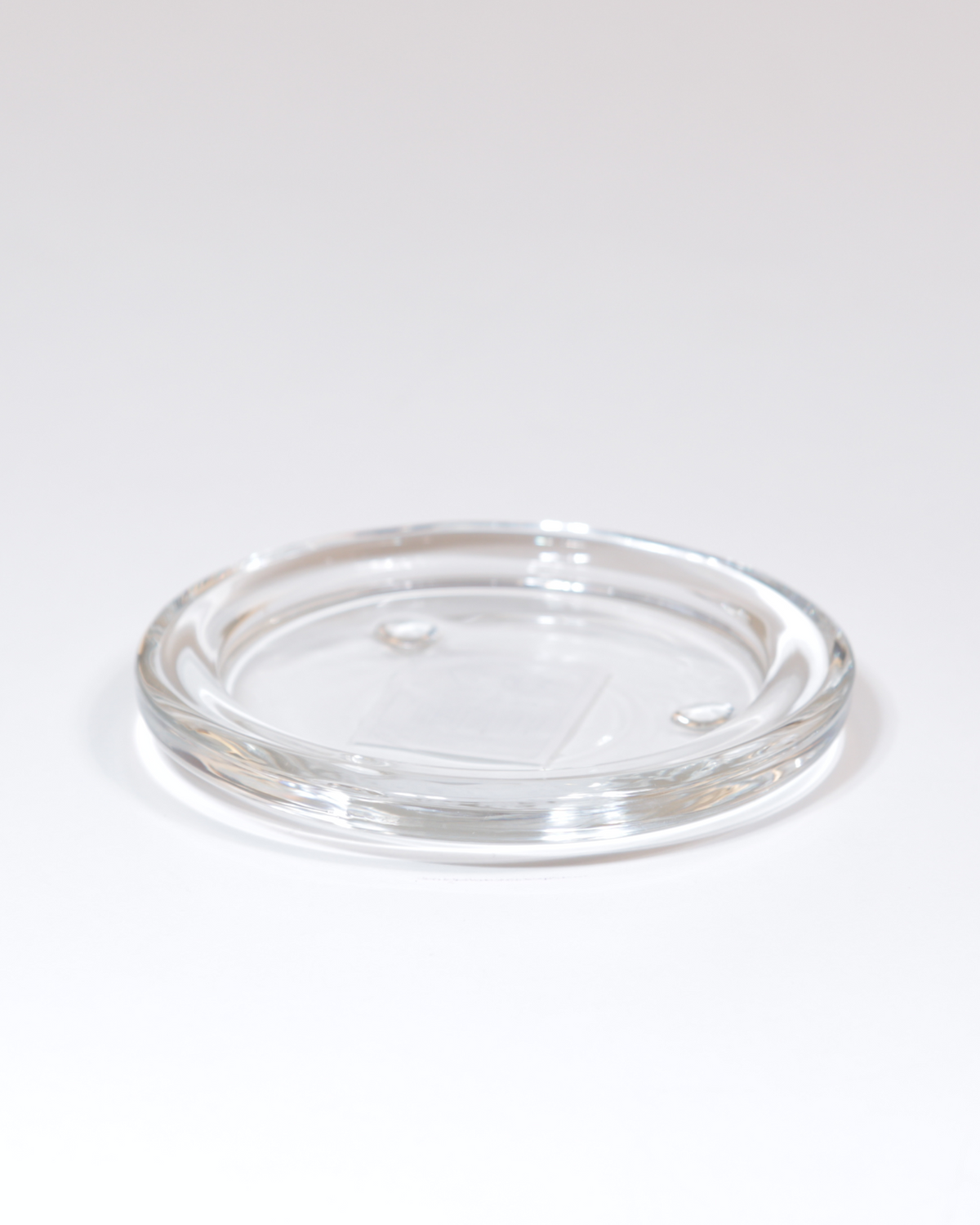 Kerzenteller aus klarem Glas mit glatter Oberfläche in der kleinen Größe.